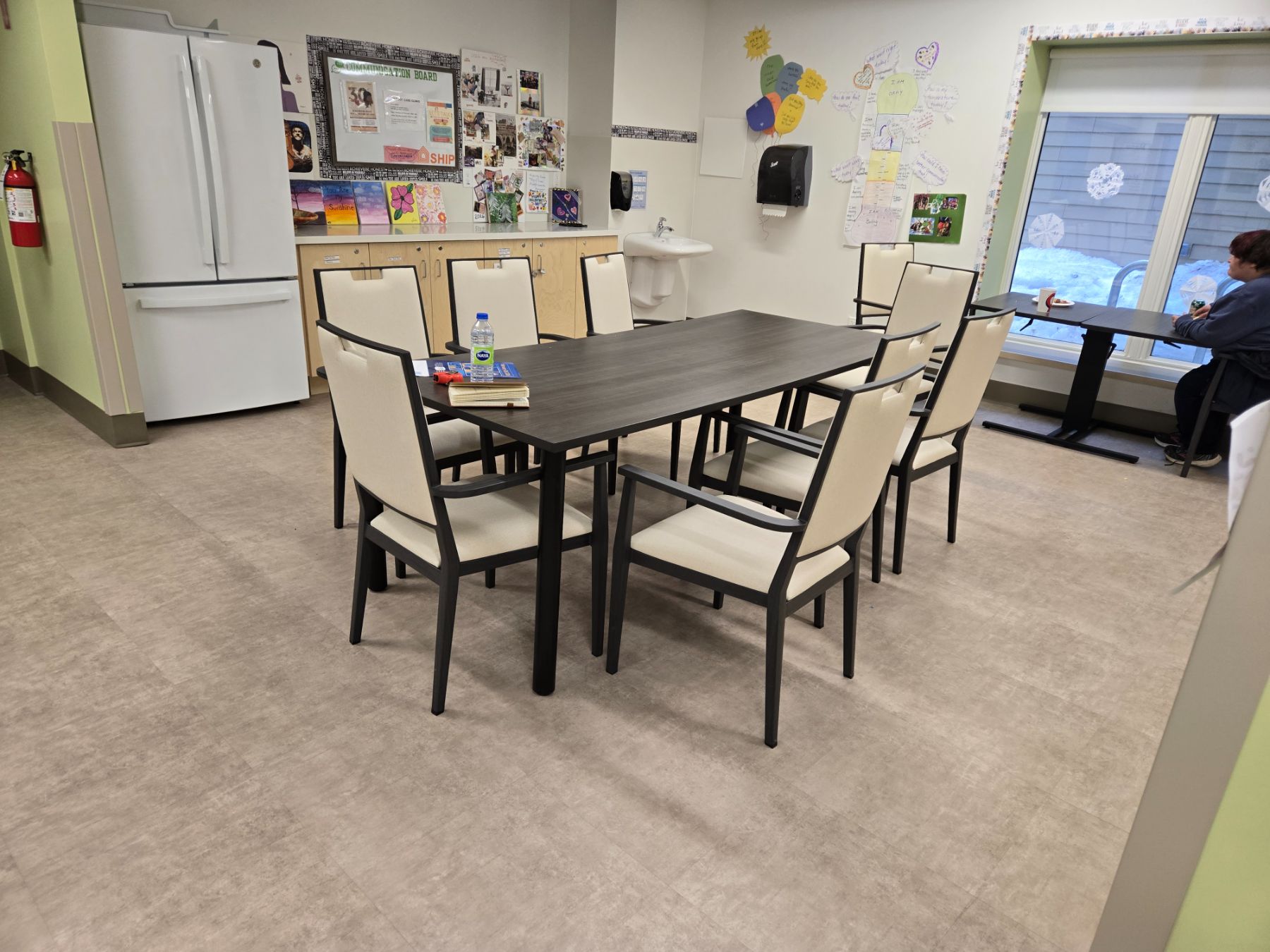 Care-community dining and activity room furnished with IntelliCare dining tables and upholstered dining chairs